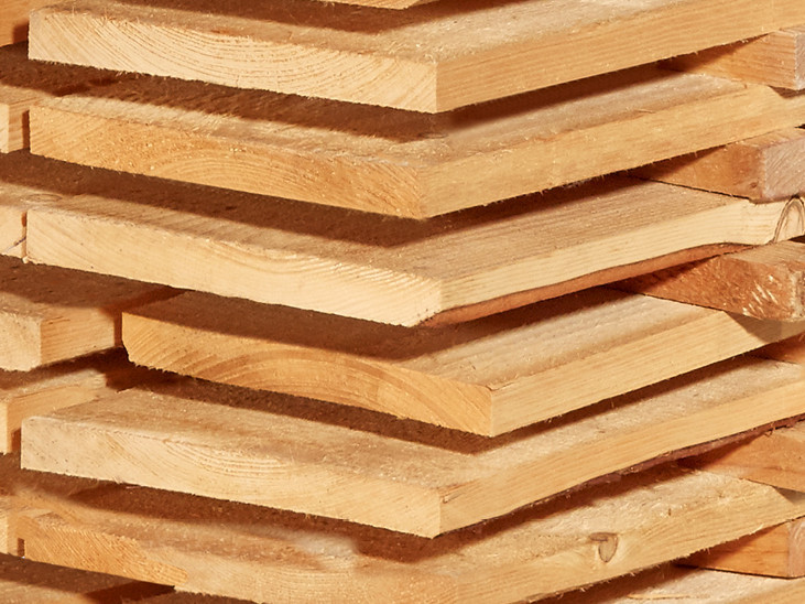 Gestapelte Schalbretter aus Holz mit sägerauer Oberfläche, ideal für den Bau- und Konstruktionsbereich.
